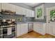 Close up of a well-lit kitchen with granite counters, stainless appliances, and mosaic backsplash at 351 Bannock St, Denver, CO 80223
