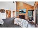 Spacious bedroom featuring wood accents, rustic decor, and a mountain view at 1055 Saddleback Dr, Evergreen, CO 80439