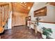 Elegant entryway features wood ceilings and trim with a grand staircase and rustic table at 1055 Saddleback Dr, Evergreen, CO 80439