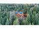 Stunning log home surrounded by lush evergreens, featuring a large deck and a private, wooded setting at 1055 Saddleback Dr, Evergreen, CO 80439