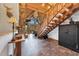 Inviting living room showcasing wooden walls and vaulted ceilings with natural log stairs at 1055 Saddleback Dr, Evergreen, CO 80439