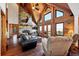 Living room boasts a stone fireplace, wood floors, and large windows with scenic views at 1055 Saddleback Dr, Evergreen, CO 80439
