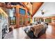 Expansive living room with floor-to-ceiling windows, hardwood floors, and a stone fireplace at 1055 Saddleback Dr, Evergreen, CO 80439