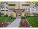 Condominium entrance with manicured landscaping featuring colorful flowers and green plants at 610 S Alton Way # 7C, Denver, CO 80247