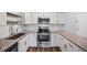 Updated kitchen featuring stainless steel appliances, white cabinets, and granite countertops at 610 S Alton Way # 7C, Denver, CO 80247
