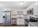 Bright kitchen with stainless steel appliances, granite counters, and new white cabinetry at 610 S Alton Way # 7C, Denver, CO 80247
