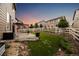 Backyard featuring an artificial lawn, stone landscaping, concrete patio, pergola, and white fence for privacy at 2633 Garganey Dr, Castle Rock, CO 80104