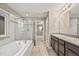 Bathroom with double sinks, granite counters, and a bathtub with glass doors at 2633 Garganey Dr, Castle Rock, CO 80104