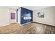 Modern bedroom with wood floors, blue accent wall, and ample natural light from a window at 2633 Garganey Dr, Castle Rock, CO 80104