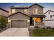 Inviting two-story home featuring a covered porch, stone accents, a two car garage, and solar panels at 2633 Garganey Dr, Castle Rock, CO 80104
