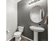 Half bathroom with pedestal sink, round mirror, and modern fixtures at 2633 Garganey Dr, Castle Rock, CO 80104