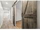 Hallway with wood-look tile, with large sliding barn door opening to another room at 2633 Garganey Dr, Castle Rock, CO 80104