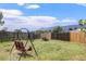 Large, grassy backyard featuring a swing set, wood fence, and views of distant mountains at 17464 Crestview Ct, Monument, CO 80132