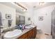Bathroom showcasing a double sink vanity, large mirror, and tile flooring at 17464 Crestview Ct, Monument, CO 80132