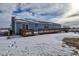Backyard view of the light blue home featuring a large wooden deck and snowy yard at 1901 Blue Mountain Ave, Berthoud, CO 80513