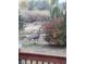 Backyard view of a deer feeding on a bush in a grassy, landscaped area next to a wooden deck railing at 1901 Blue Mountain Ave, Berthoud, CO 80513