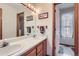 The well-lit bathroom features double sinks, wood cabinets, and a view to another bathroom at 1901 Blue Mountain Ave, Berthoud, CO 80513