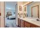 The well-lit bathroom features double sinks, wood cabinets, and a view to the bedroom at 1901 Blue Mountain Ave, Berthoud, CO 80513