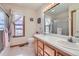 Well-lit bathroom featuring double sinks, a shower with glass doors, and a window with patterned curtains at 1901 Blue Mountain Ave, Berthoud, CO 80513