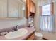 Compact bathroom offers a practical layout with a vanity, toilet, and overhead storage at 1901 Blue Mountain Ave, Berthoud, CO 80513