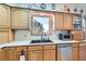 Well-lit kitchen featuring wood cabinets, modern appliances, and a view of the outdoors from the window at 1901 Blue Mountain Ave, Berthoud, CO 80513