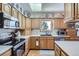 Well-lit kitchen featuring wood cabinets, modern appliances, and a view of the outdoors from the window at 1901 Blue Mountain Ave, Berthoud, CO 80513