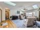 Bright living room featuring a vaulted ceiling, skylights, comfortable seating, and a glimpse of the hallway at 1901 Blue Mountain Ave, Berthoud, CO 80513