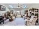 Cozy living room featuring plush seating, large windows, and a ceiling fan, with natural light from skylights at 1901 Blue Mountain Ave, Berthoud, CO 80513