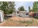 Exterior shot of home from backyard with white siding and door and detached garage at 1925 Syracuse St, Denver, CO 80220