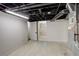 Basement area with tile floors, exposed ceiling, and access to another room at 1925 Syracuse St, Denver, CO 80220
