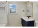Bathroom featuring navy vanity, stylish mirror, and shower with white subway tile at 1925 Syracuse St, Denver, CO 80220