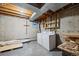Unfinished basement laundry area with washer and dryer, exposed ceilings, and concrete flooring at 9659 W Cornell Pl, Lakewood, CO 80227
