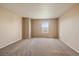 Bedroom featuring a large window, neutral walls, and plush carpeting, with closet and bathroom entrances at 9659 W Cornell Pl, Lakewood, CO 80227