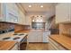 Bright kitchen featuring white cabinets, appliances, and an open floor plan at 9659 W Cornell Pl, Lakewood, CO 80227