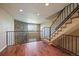 Stylish living space featuring hardwood floors, a brick accent wall, and staircase at 9659 W Cornell Pl, Lakewood, CO 80227