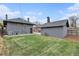 A spacious backyard features a well-maintained lawn, detached garage, and access to the home's back entrance at 2659 Ash St, Denver, CO 80207