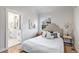 Cozy bedroom with hardwood floors, a comfortable bed, and a view into the bathroom at 2659 Ash St, Denver, CO 80207