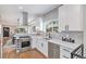 Well-lit kitchen featuring stainless steel appliances, white cabinets, and a view into the dining room at 2659 Ash St, Denver, CO 80207