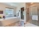 Bright bathroom with soaking tub, separate shower, and a window that offers natural light at 13962 Dexter Way, Thornton, CO 80602