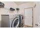 Functional laundry room featuring modern washer and dryer units, and storage shelving at 13962 Dexter Way, Thornton, CO 80602