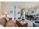 Open-concept living space with carpeted floor, stairs and dining area with chandelier at 13962 Dexter Way, Thornton, CO 80602