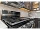 Stainless steel gas range and microwave complement the dark cabinetry and light backsplash at 4078 Happy Hollow Dr, Castle Rock, CO 80104