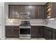 Modern kitchen with stainless steel appliances, dark cabinetry, and stylish backsplash at 4078 Happy Hollow Dr, Castle Rock, CO 80104