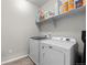 A well lit laundry room with a washing machine and dryer, and storage shelves above at 4078 Happy Hollow Dr, Castle Rock, CO 80104