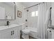 Updated bathroom with new vanity, a mirror, and shower with marble tiling at 957 Newton St, Denver, CO 80204