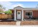Attractive brick home featuring a covered entrance and well-kept landscaping at 957 Newton St, Denver, CO 80204