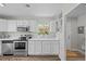 Bright kitchen with white cabinets, stainless steel appliances, and wood-look floors at 957 Newton St, Denver, CO 80204