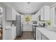 The renovated kitchen features modern appliances, lots of cabinets, sleek countertops, and lovely outdoor views at 957 Newton St, Denver, CO 80204