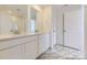 Bathroom with double vanity, quartz counters, modern faucets, and marble-look tile flooring at 7276 Waterleaf Trl, Littleton, CO 80125