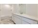 Bathroom with tub and shower, quartz counters, modern faucets, and marble-look tile flooring at 7276 Waterleaf Trl, Littleton, CO 80125